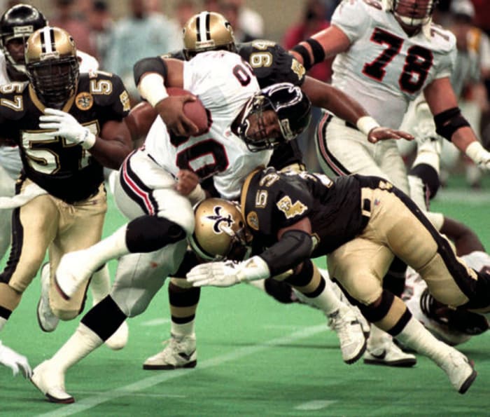 Saints LB Vaughan Johnson (53) brings down Atlanta WR Andre Risen (80) in a 1991 Wild-Card matchup. Credit: si.com